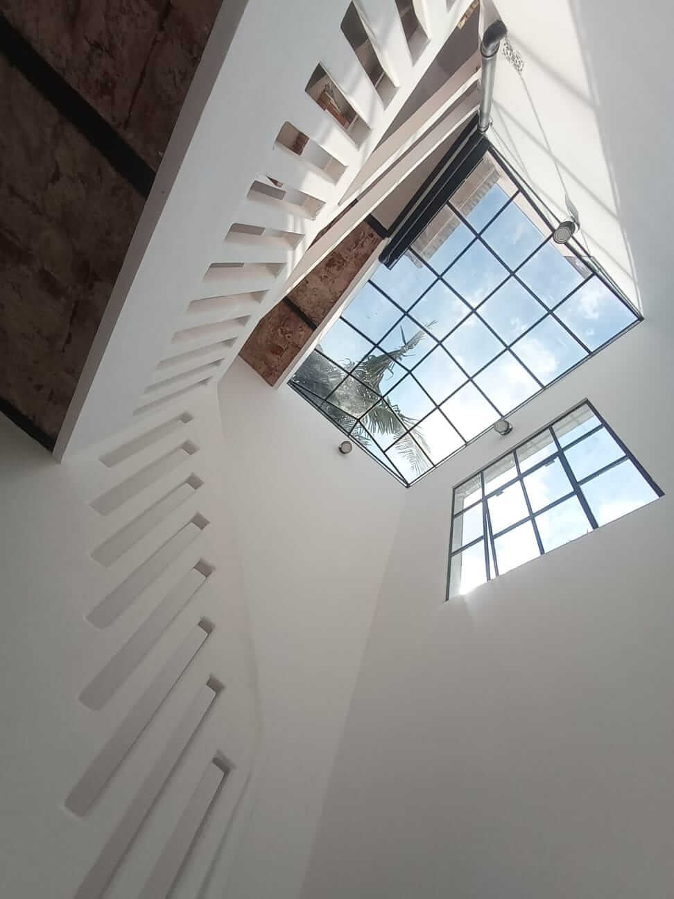 Escalera antigua reciclada con cúpula en hierro y vidrio.