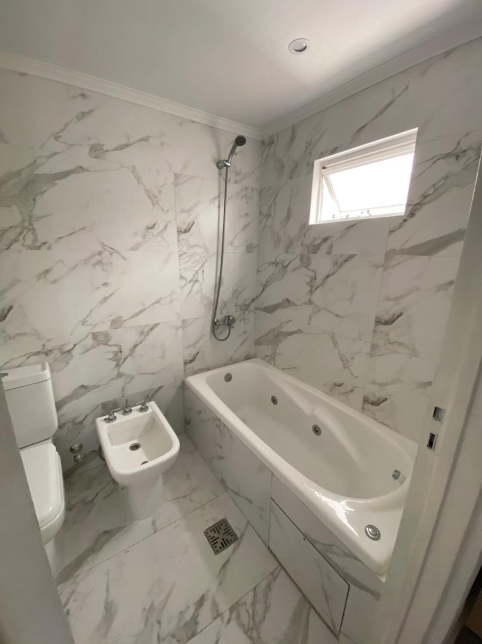 Baño con revestimiento estilo mármol.