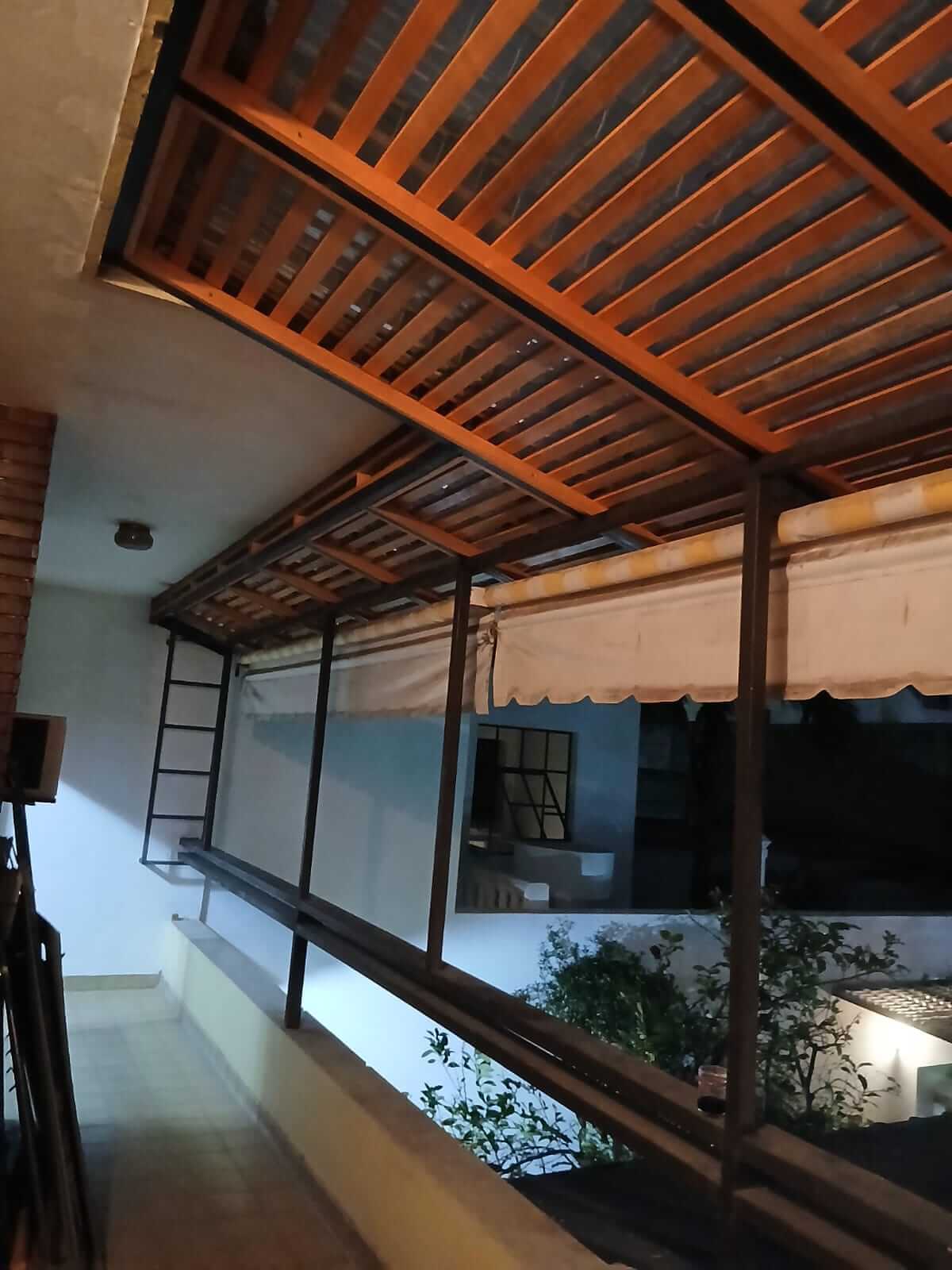 Cerramiento de balcon con pergola de madera cubierta.