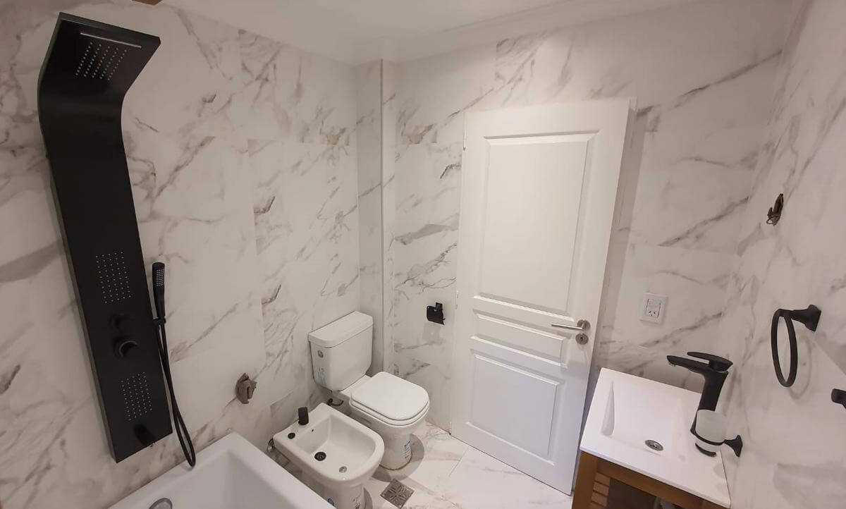 Baño con revestimiento tipo marmol.