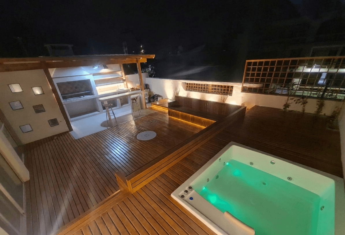 Deck de madera con pergola, parilla y jacuzzi de noche
