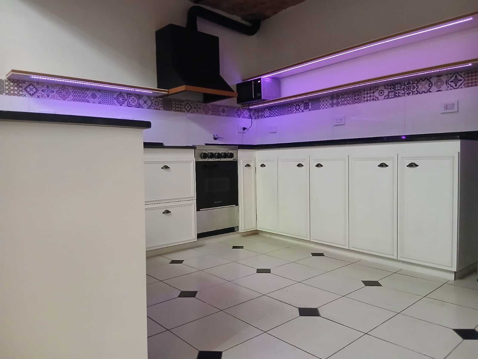 Mueble de cocina blanco amplia con iluminacion.